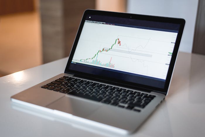 Close-up of a laptop displaying a financial trading graph used for expense analysis
